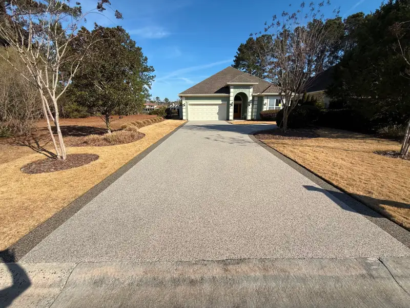 Long Alaskan Tundra driveway with dark borders leading to a house