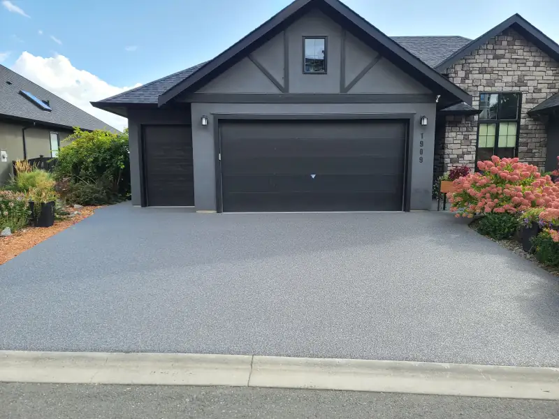 Grey Manhattan blend resin-bound driveway in front of a modern two-car garage