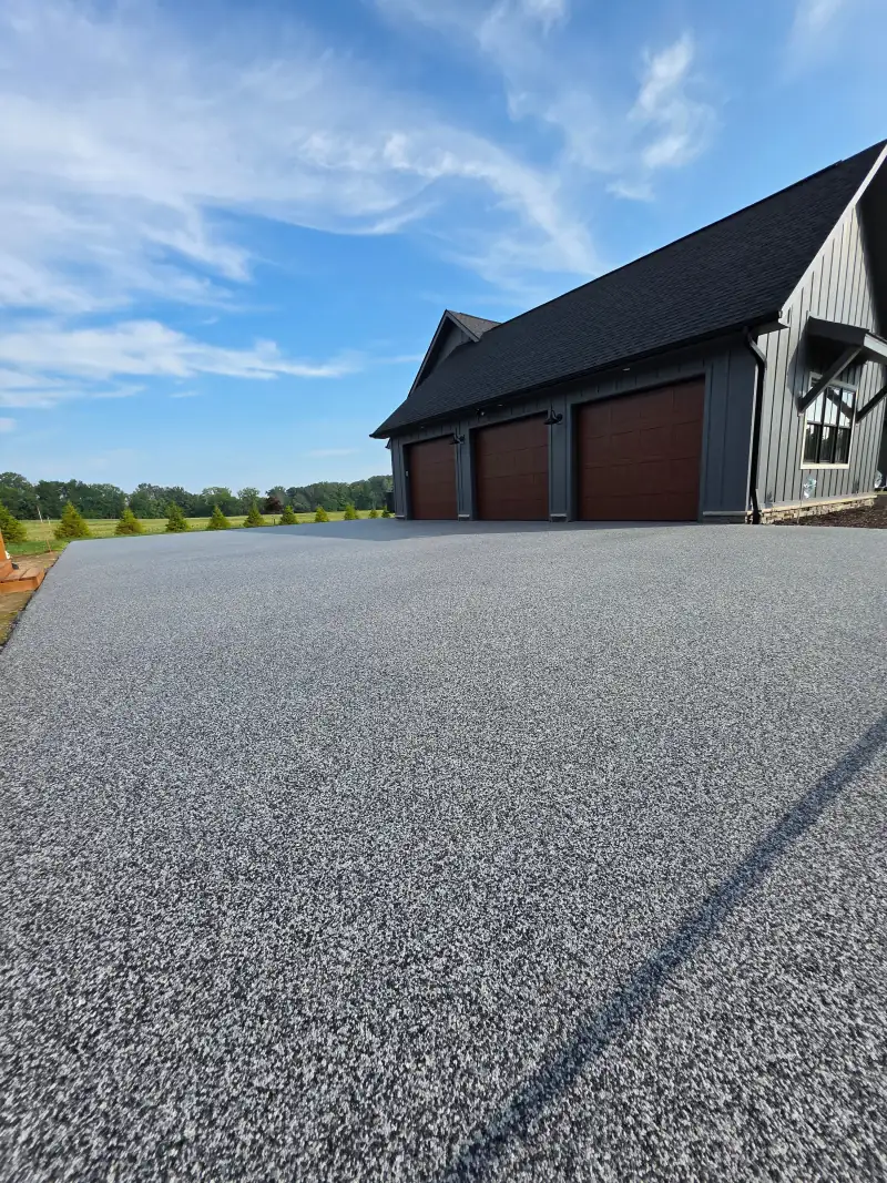 Palazzo blend driveway with a contrasting border in front of a three-car garage