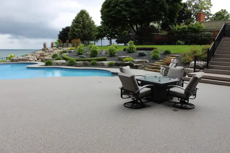 Palazzo blend pool deck with patio furniture beside a lake